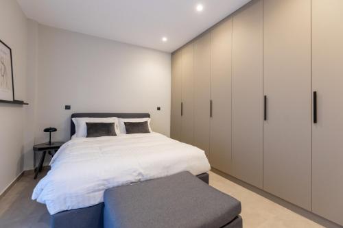 a bedroom with a bed and white cabinets at Kaleo Chios Luxury Apartments in Chios
