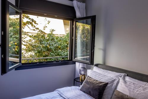a bedroom with a bed and two windows at Kaleo Chios Luxury Apartments in Chios