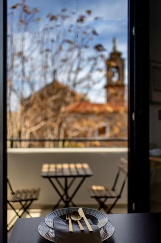 a table with two forks and a plate on a balcony at Kaleo Chios Luxury Apartments in Chios