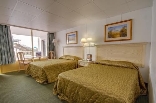 um quarto de hotel com duas camas e uma varanda em Empress Motel em Ocean City