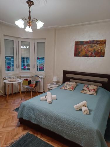 a bedroom with a bed with towels on it at Bohemian Dawn Apartment in Belgrade