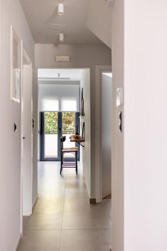 a hallway with white walls and a dining room at Kaleo Chios Luxury Apartments in Chios
