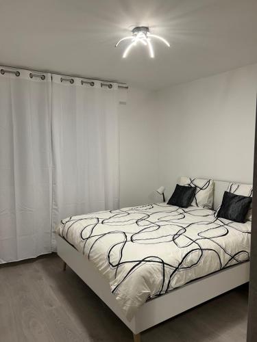 a white bedroom with a bed and a ceiling fan at Mandana in Strasbourg