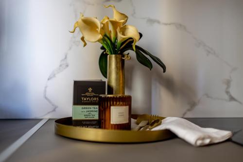 a table with a vase with flowers and a candle at Kaleo Chios Luxury Apartments in Chios