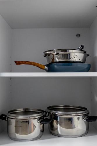 two pots and pans on a shelf in a kitchen at Kaleo Chios Luxury Apartments in Chios