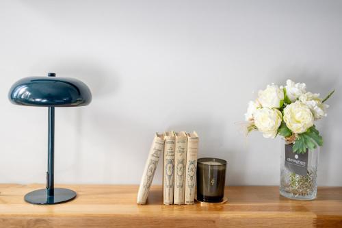 a table with a vase of white flowers and books at Kaleo Chios Luxury Apartments in Chios