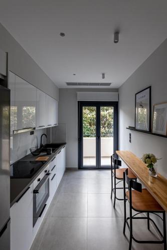 a kitchen with white cabinets and a wooden table at Kaleo Chios Luxury Apartments in Chios