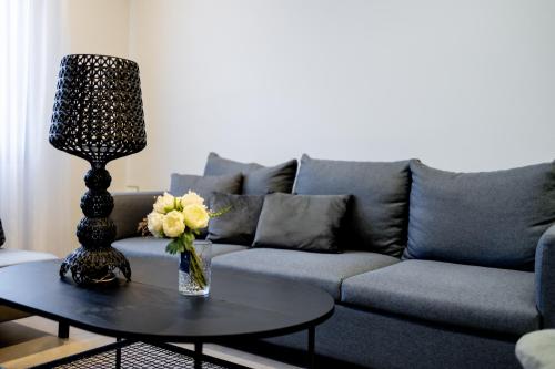a living room with a couch and a table with a lamp at Kaleo Chios Luxury Apartments in Chios