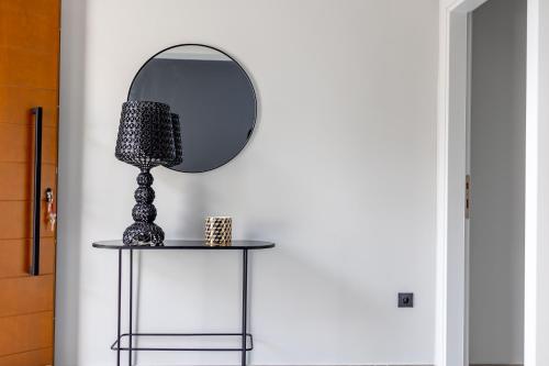 a table with a mirror on a wall at Kaleo Chios Luxury Apartments in Chios