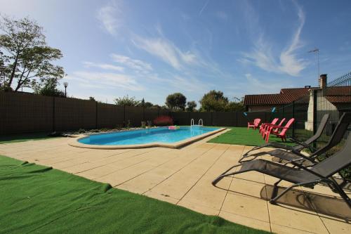 a backyard with a swimming pool and a chair at Maison Ravi in Lectoure