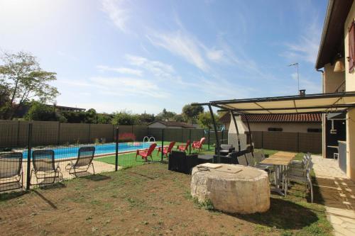 a backyard with a pool with chairs and a table at Maison Ravi in Lectoure