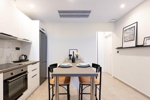 a kitchen and dining room with a table and chairs at Kaleo Chios Luxury Apartments in Chios