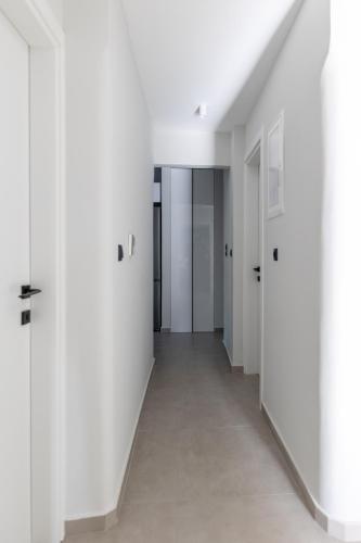 an empty hallway with white walls and white floors at Kaleo Chios Luxury Apartments in Chios