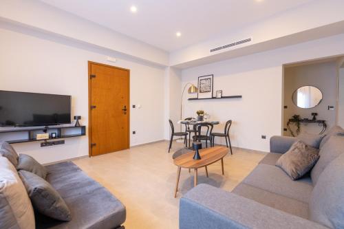 a living room with a couch and a table at Kaleo Chios Luxury Apartments in Chios