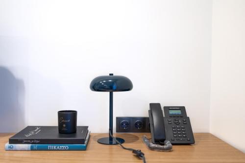 a desk with a phone and a lamp and a book at Kaleo Chios Luxury Apartments in Chios