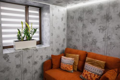 a living room with an orange couch and a window at Apart 1 Chernivtsy in Chernivtsi