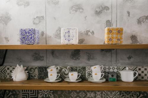a shelf with cups and saucers on it at Apart 1 Chernivtsy in Chernivtsi