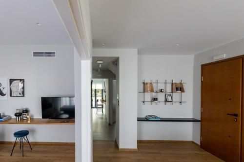 a room with white walls and a wooden desk at Kaleo Chios Luxury Apartments in Chios