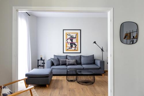 a living room with a blue couch and a table at Kaleo Chios Luxury Apartments in Chios