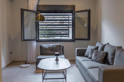 a living room with a couch and a table at Kaleo Chios Luxury Apartments in Chios