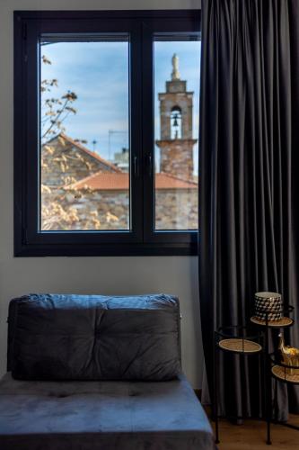 a bedroom with a window with a view of a church at Kaleo Chios Luxury Apartments in Chios