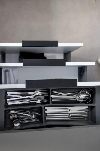 a shelf with plates and silverware on it at Kaleo Chios Luxury Apartments in Chios