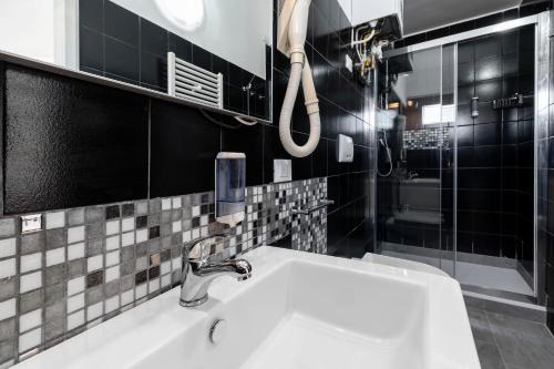 W łazience znajduje się umywalka i prysznic. w obiekcie Ca' dei Carmini w Wenecji