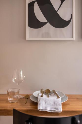 a table with a plate and a napkin and a glass at Kaleo Chios Luxury Apartments in Chios