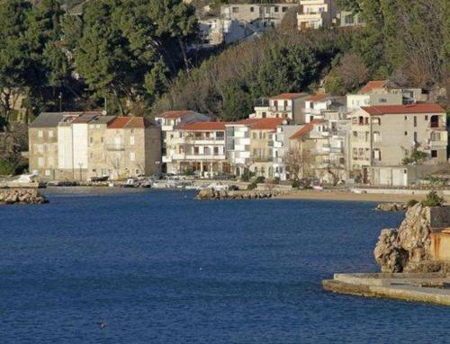a group of buildings next to a large body of water at Apartments Juraj in Drasnice