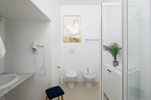a white bathroom with a toilet and a sink at Trevi Fountain Guesthouse in Rome