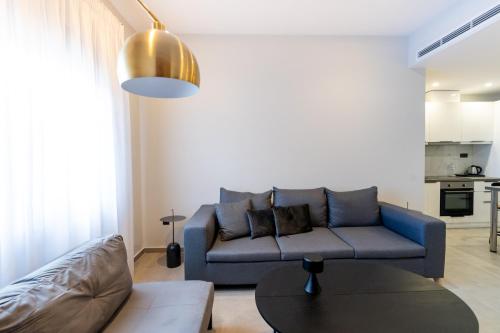 a living room with a blue couch and a table at Kaleo Chios Luxury Apartments in Chios
