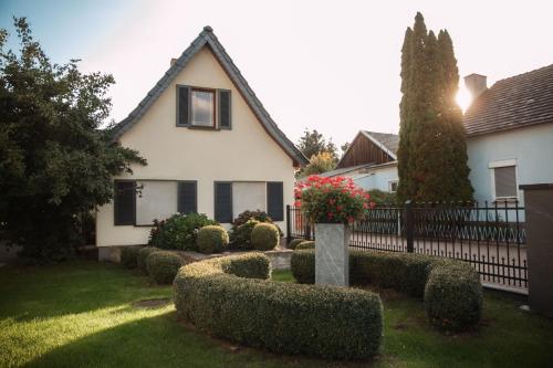 een huis met heggen voor een tuin bij Ferienhaus LORINI in Kolkwitz