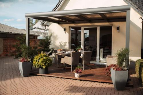 eine Terrasse mit einem Tisch und einigen Pflanzen in der Unterkunft Ferienhaus LORINI in Kolkwitz