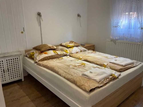 ein Schlafzimmer mit einem großen Bett mit Kissen darauf in der Unterkunft Apartment Balatonbereny 2 in Balatonberény