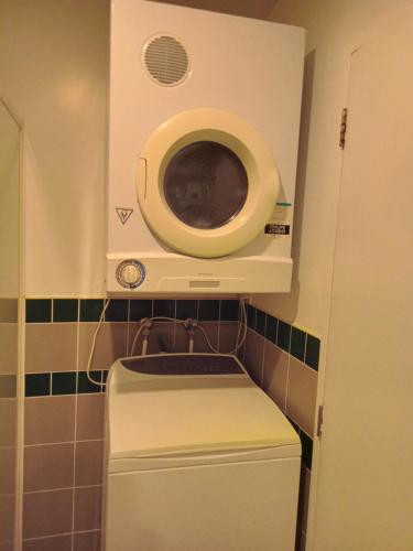 pralka i suszarka w małej łazience w obiekcie Central one bedroom apartment w Auckland