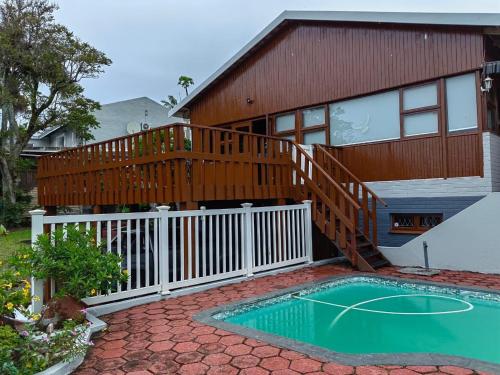 a house with a deck and a swimming pool at Msongi Guest House in Margate