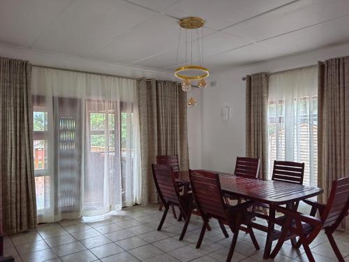a dining room with a table and chairs and windows at Msongi Guest House in Margate