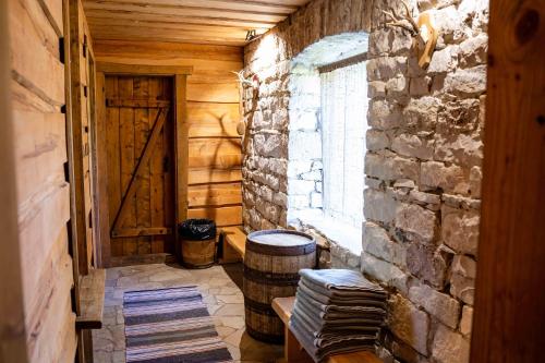 a room with a stone wall and a door and a barrel at Vanatoa Taluhotell in Koguva