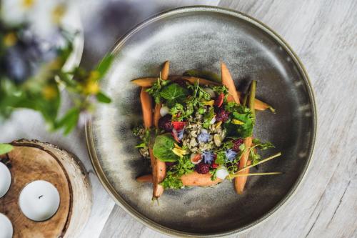 a plate of food with vegetables on a table at Chata nad Wąwozem in Nałęczów