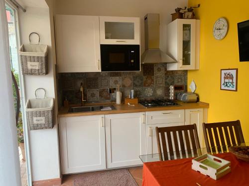 a kitchen with white cabinets and a table with chairs at Villa Melissa in Diano Castello
