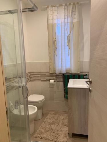 a bathroom with a toilet and a sink and a shower at Villa Melissa in Diano Castello