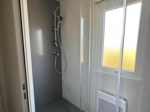 La salle de bains est pourvue d'une douche avec une porte en verre. dans l'établissement Superbe Mobil home 6-8 personnes (57), à Saint-Jean-de-Monts