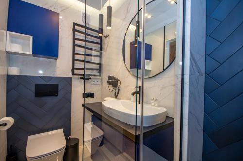 a bathroom with a sink and a toilet and a mirror at InPoint Central Apartments in Kraków