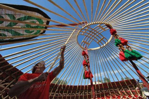 a man standing in front of a ferris wheel at Nomadic Life in a yurt in Bügat