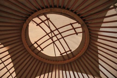 Nomadic Life in a yurt في Bügat: نافذة مستديرة في سقف المبنى