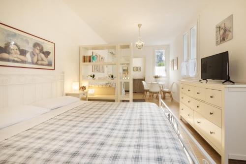 1 dormitorio blanco con 1 cama grande y TV en B&B Cá Bianca Ventisette Riccione, en Riccione