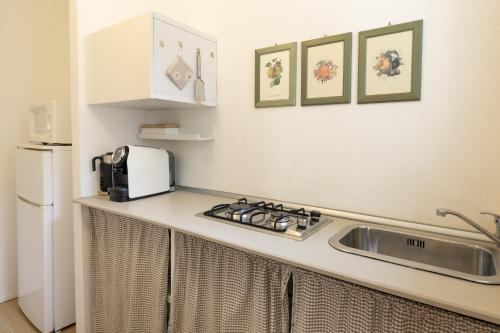 a kitchen with a sink and a counter with a microwave at B&B Cá Bianca Ventisette Riccione in Riccione