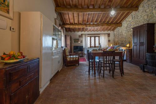 a kitchen with a refrigerator and a table with chairs at Podere Colombaio - Bucaneve in Radicofani