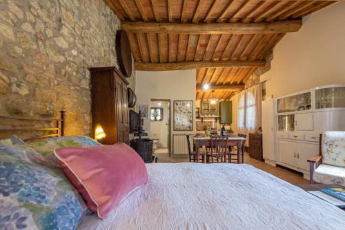 a bedroom with a large bed and a dining room at Podere Colombaio - Bucaneve in Radicofani