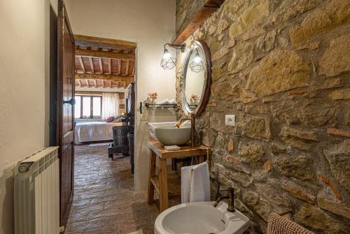 Baño de piedra con lavabo y espejo en Podere Colombaio - Bucaneve en Radicofani